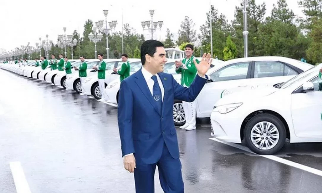 Presidente do Turcomenistão acena em frente aos carros brancos de autoridades do seu governo - Foto: Reprodução/X